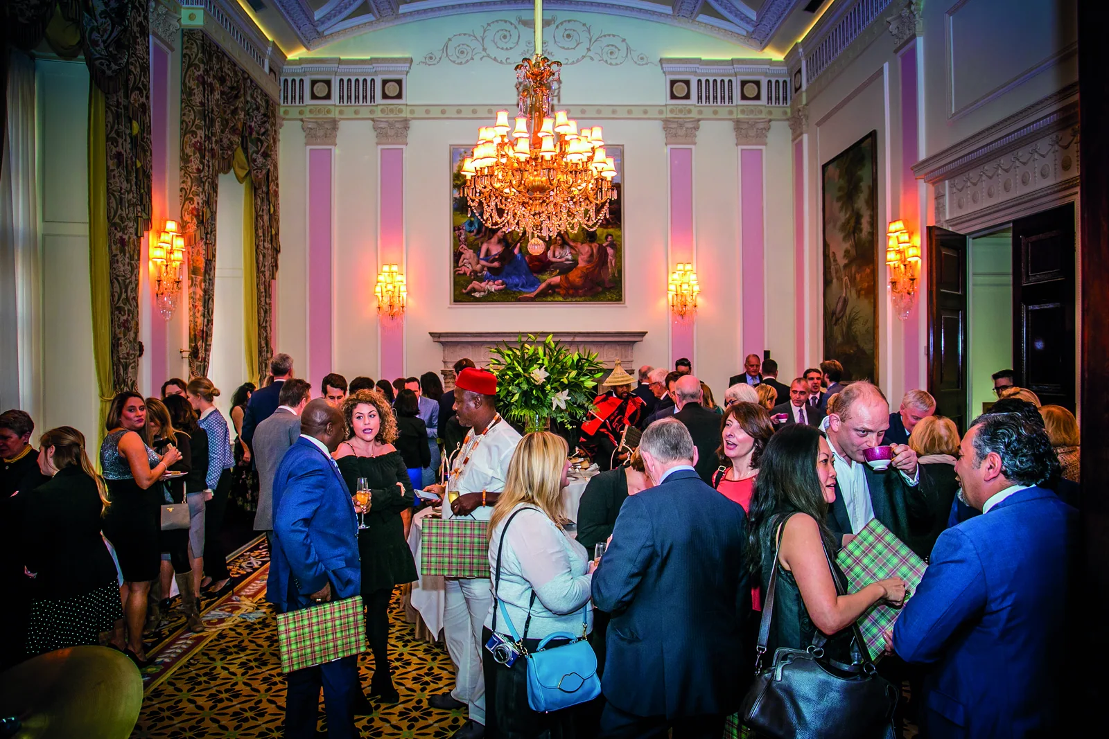 Guests in conversation in a chandelier-lit reception room