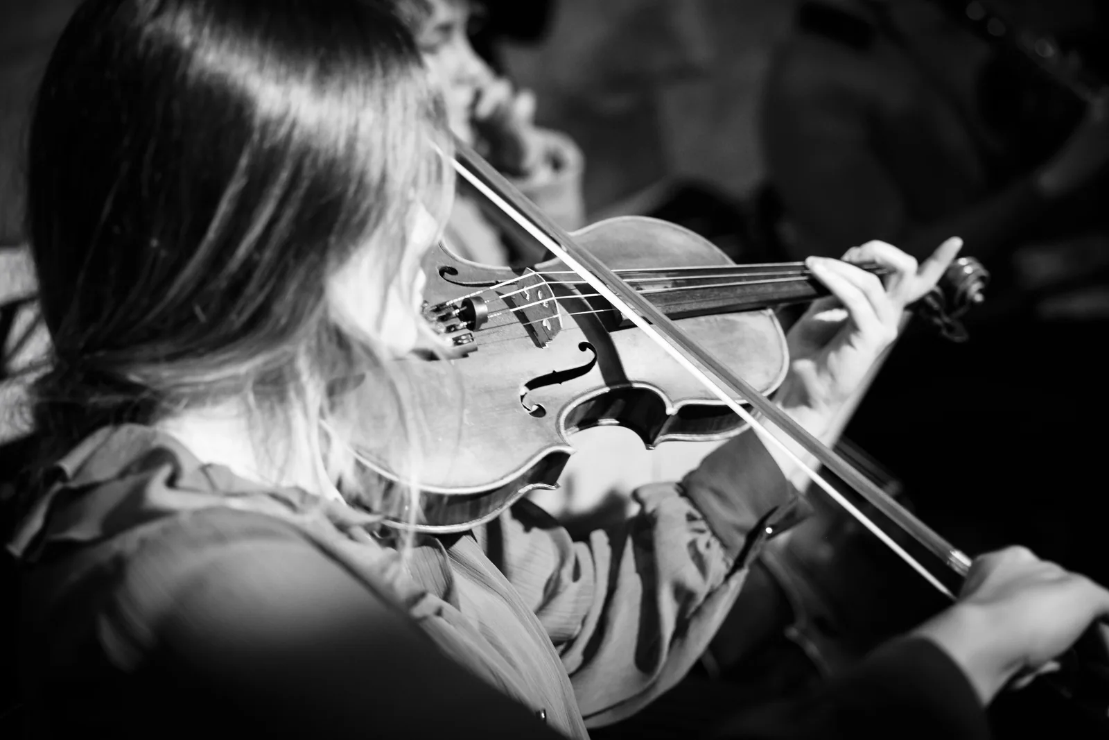 A violinist performing at an event, in black and white