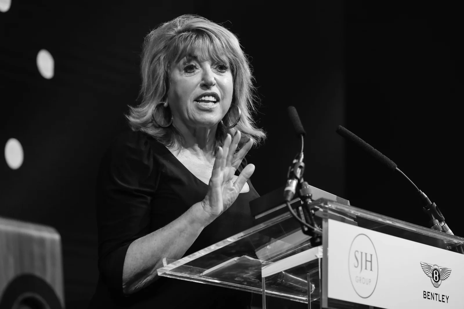 A speaker at a lectern, photographed in black and white