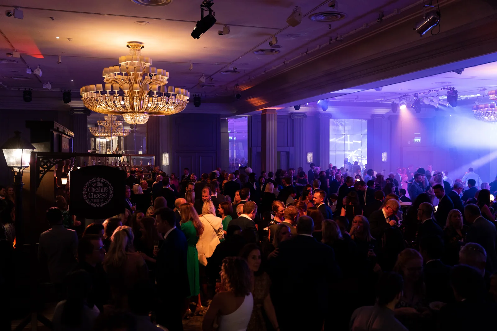 A full event room with dramatic blue lighting